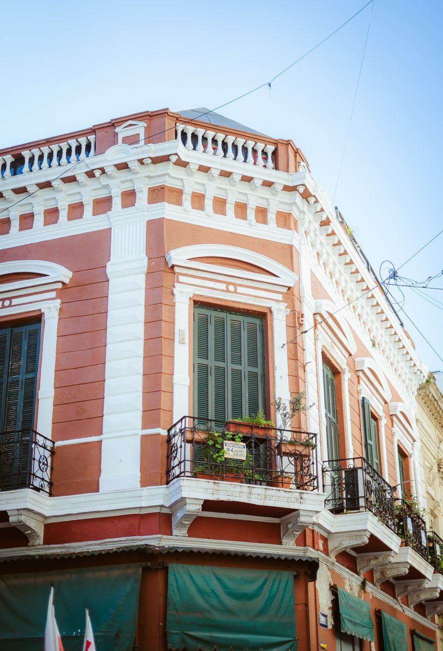 Fachada clásica de café histórico con mesas y faroles